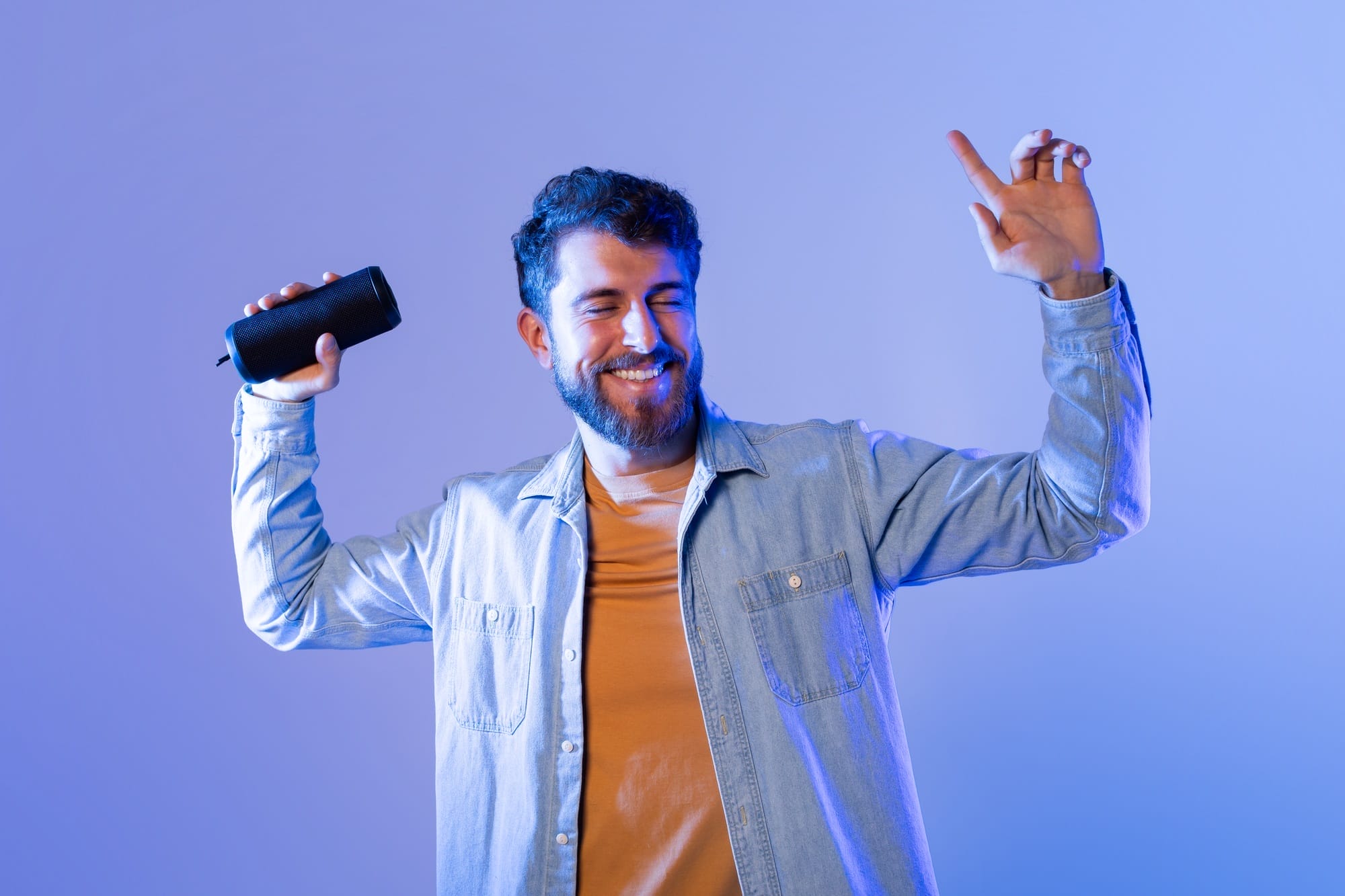 Man Enjoys Music While Dancing With Bluetooth Speaker